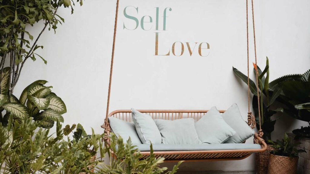 self love text wall background with swinging chair